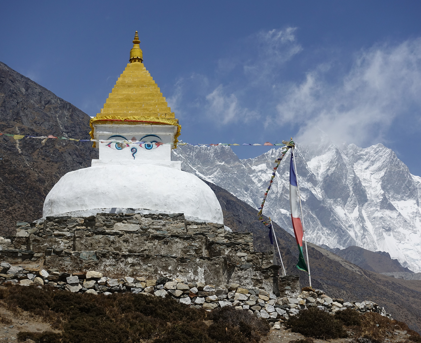 Experience a fabulous blend of natural and cultural sights and scenery on the trek to Everest Base Camp - here a large Buddhist stupa strikes a brilliant contrast to the Himalayan mountains behind.